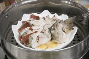 將鱸魚成花狀擺好，將火腿切片放入各縫隙中，放入鍋中隔水蒸12分鐘拿出，撒上蔥花即可。