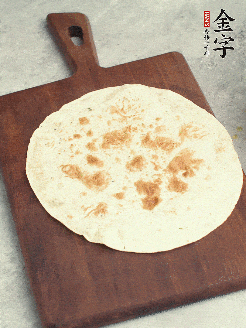 食材依次鋪在卷餅皮上，卷起來。