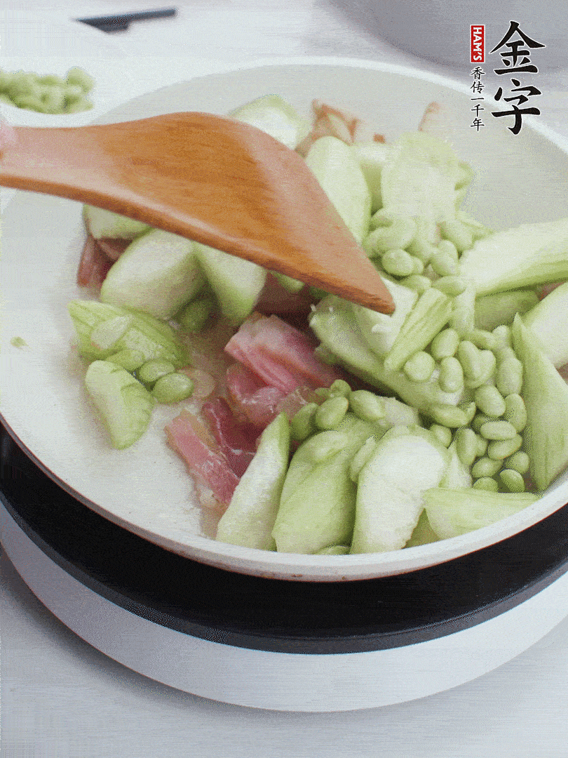 依次下絲瓜、青豆翻炒，炒至絲瓜打蔫縮小。