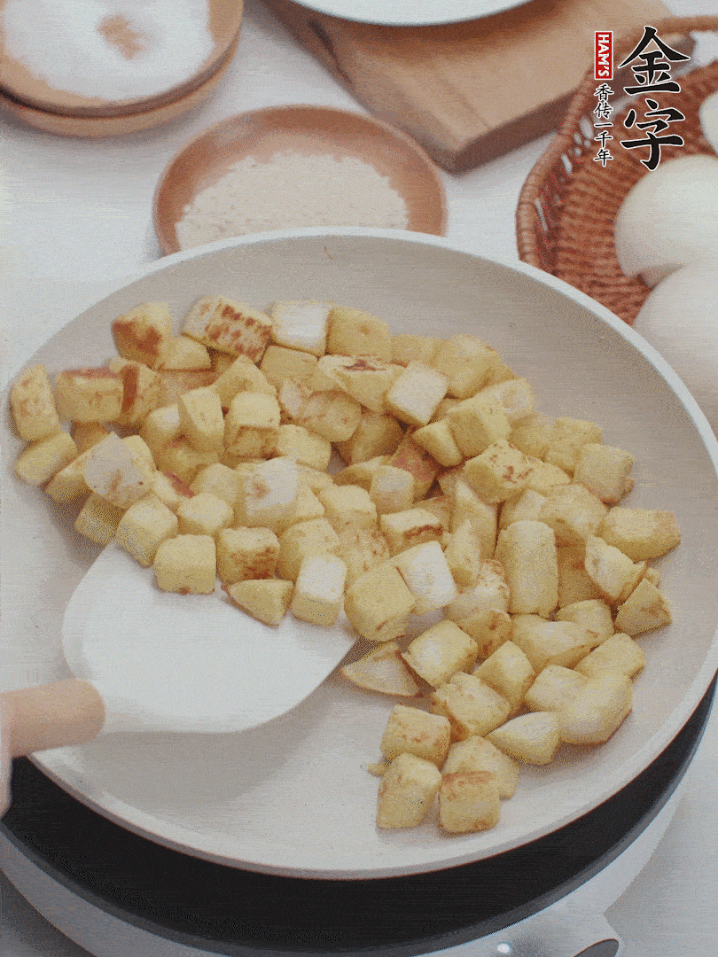 起鍋熱油，倒入饅頭丁，小火煎至蛋液凝固定型再翻面，饅頭丁部煎至金黃時盛起待用。
