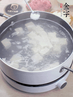 豆腐切成大小均勻正方體，鍋內(nèi)放水，加一點鹽焯水10秒。