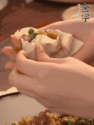 取一大勺餡料放進餃子皮里，用大拇指按住頂部餡料，再用虎口掐出形狀。