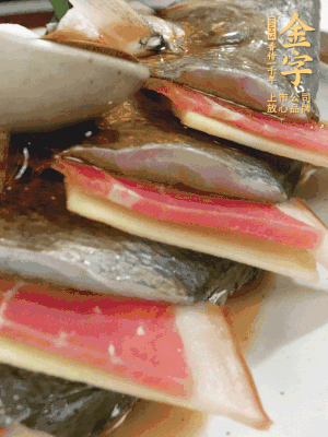 魚肚中塞蔥結(jié)、火腿片，魚身上碼放姜片、火腿片，倒入混合的料汁。